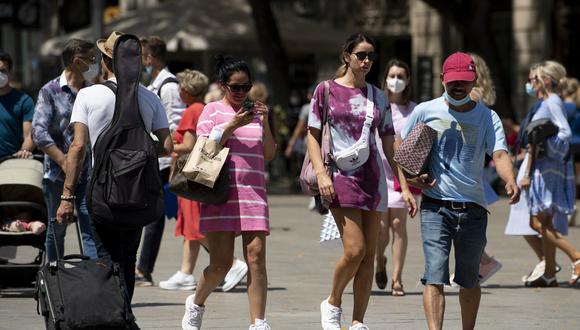 La gente camina sin usar máscaras faciales en Barcelona el 26 de junio de 2021. (Foto: Josep LAGO / AFP)