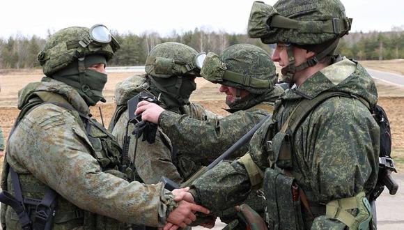 Soldados de Rusia (izq.) y Bielorrusia (der.) dándose la mano durante ejercicios conjuntos. (AFP).