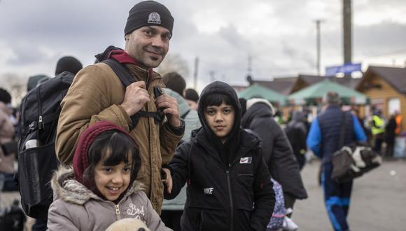 Ajmal Rahmani de Afganistán y sus hijos son vistos como refugiados de muchos países diferentes, de África, Medio Oriente e India, en su mayoría estudiantes de universidades ucranianas en el cruce fronterizo peatonal de Medyka que huyen del conflicto en Ucrania, en el este de Polonia el 27 de febrero, 2022.(Foto de Wojtek RADWANSKI / AFP)