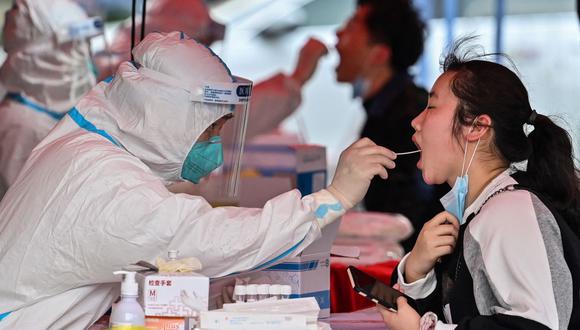 Una mujer se hace la prueba de coronavirus covid-19 en el distrito de Hongkou, en Shanghai, China, el 16 de marzo de 2022. (Héctor RETAMAL / AFP).