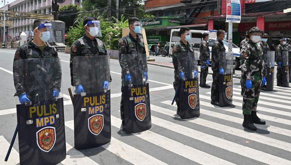 En esta foto tomada el 8 de septiembre de 2020, agentes de policía con caretas protectoras montan guardia cerca de una puerta que conduce al palacio presidencial en Manila. (AFP/Ted ALJIBE).