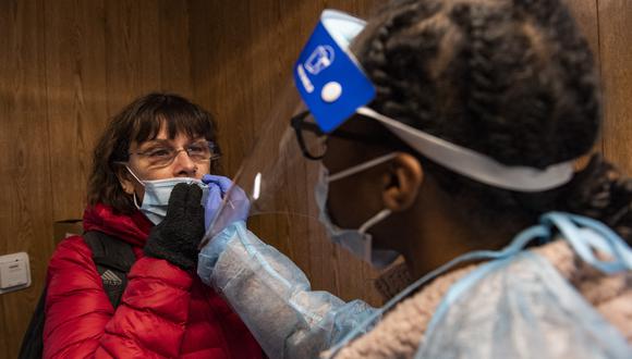 Una trabajadora de salud realiza una prueba de PCR a una mujer que quería hacerse la prueba de covid-19 en el Centro de Salud Comunitario de East Boston en Boston, Massachusetts. (Foto: Joseph Prezioso / AFP)