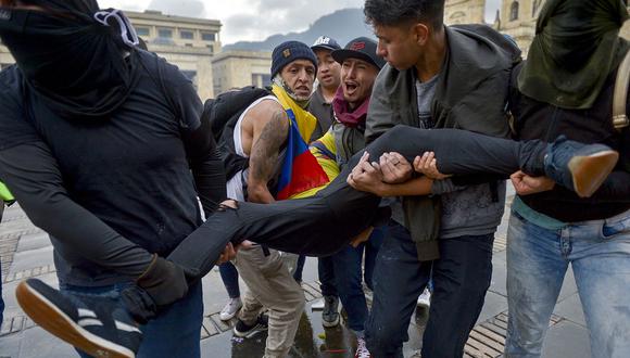 Manifestante herido es llevado por sus compañeros durante enfrentamientos por la huelga nacional convocada por estudiantes, sindicatos y grupos indígenas para protestar contra el gobierno del presidente colombiano Ivan Duque, en Bogotá. (Foto: AFP)