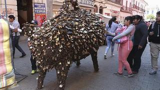 ​Cerdito de la fortuna atrae candados del amor puestos en puentes