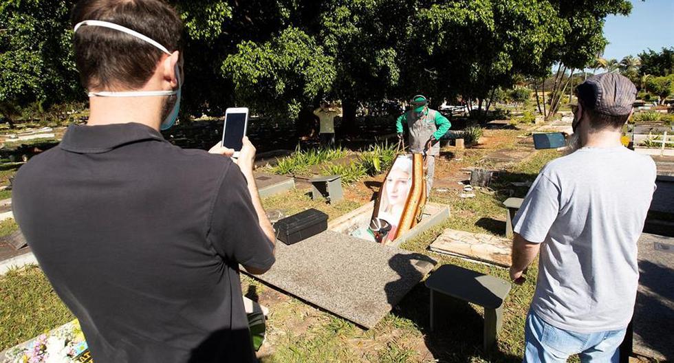 Trabajadores del cementerio Campo de Esperanza entierran una víctima de coronavirus este lunes, en Brasilia. (EFE/Joédson Alves)