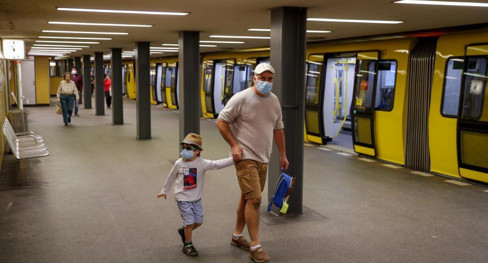 Un padre junto a su hijo usan máscaras de protección facial en la estación de metro Bahnhof Zoo, en Berlín. Se requerirán máscaras protectoras en el transporte público en la mayor parte de Alemania y en la capital, Berlín. (Odd ANDERSEN / AFP)