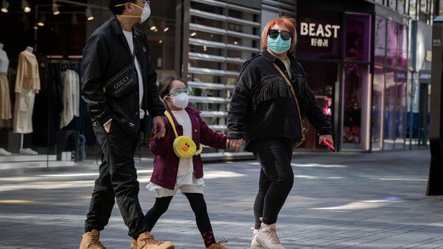 En esta imagen, tomada ayer, se aprecia a personas que usan mascarillas como medida preventiva contra el coronavirus caminando afuera de un centro comercial en Beijing. (AFP)