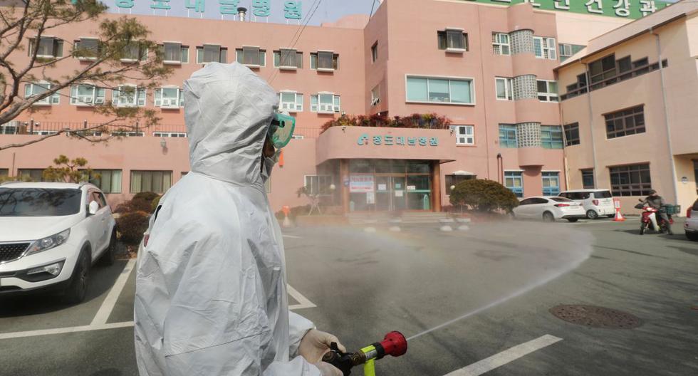 Un funcionario de salud de Corea del Sur rocía desinfectante frente a un hospital donde ahora se han identificado un total de 16 infecciones con el coronavirus COVID-19, en el condado de Cheongdo. (AFP)
