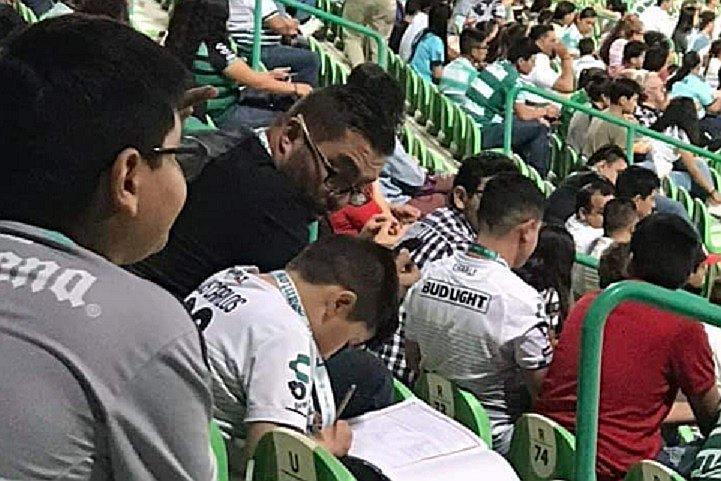 Niño va a ver un partido del equipo de sus amores y termina haciendo la tarea (FOTO)