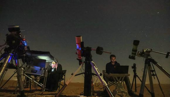 Los astrofotógrafos Mohammad al-Obaidi (R) y Abdullah al-Harbi siguen el cometa C/2022 E3 (ZTF) temprano el 2 de febrero de 2023 en el desierto de al-Salmi, a unos 120 kilómetros al noroeste de la ciudad de Kuwait. (Foto de Yasser Al-Zayyat / AFP)