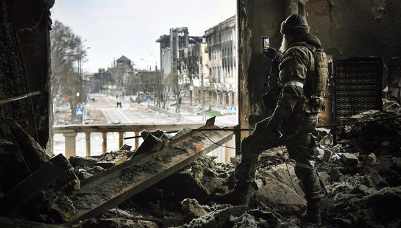 Un soldado ruso patrulla en el teatro dramático de Mariupol, bombardeado el 16 de marzo pasado, el 12 de abril de 2022 en Mariupol. (Foto de Alexander NEMENOV / AFP)