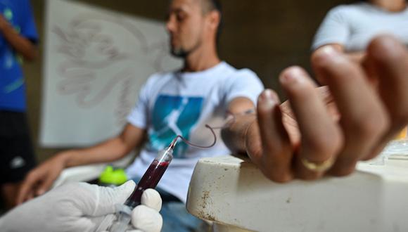 A un voluntario le extraen sangre del brazo, el 23 de marzo de 2022. (Foto por Luis ROBAYO / AFP)