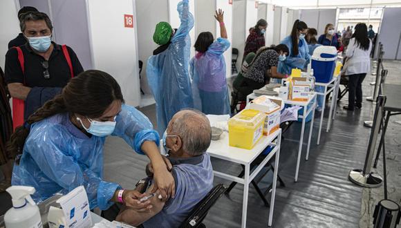 Una trabajadora de la salud inocula a un anciano con una dosis de la vacuna Sinovac COVID-19 en un centro de inmunización instalado en el Estadio Bicentenario en Santiago de Chile. (Foto AP/ Esteban Félix, archivo).