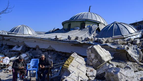 Los residentes locales se sientan junto a los escombros de una mezquita destruida en Hatay, el 10 de febrero de 2023, después del terremoto de magnitud 7,8 que mató a más de 22 mil personas.  (Foto de Yasin AKGUL / AFP)