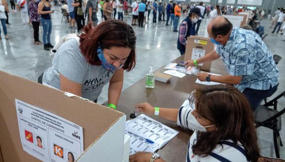 Una ciudadana peruana residente en Estados Unidos deposita su voto en el centro de sufragio ubicado en el Centro de Convenciones de Miami Beach. (EFE / EPA / CRISTOBAL HERRERA-ULASHKEVICH).