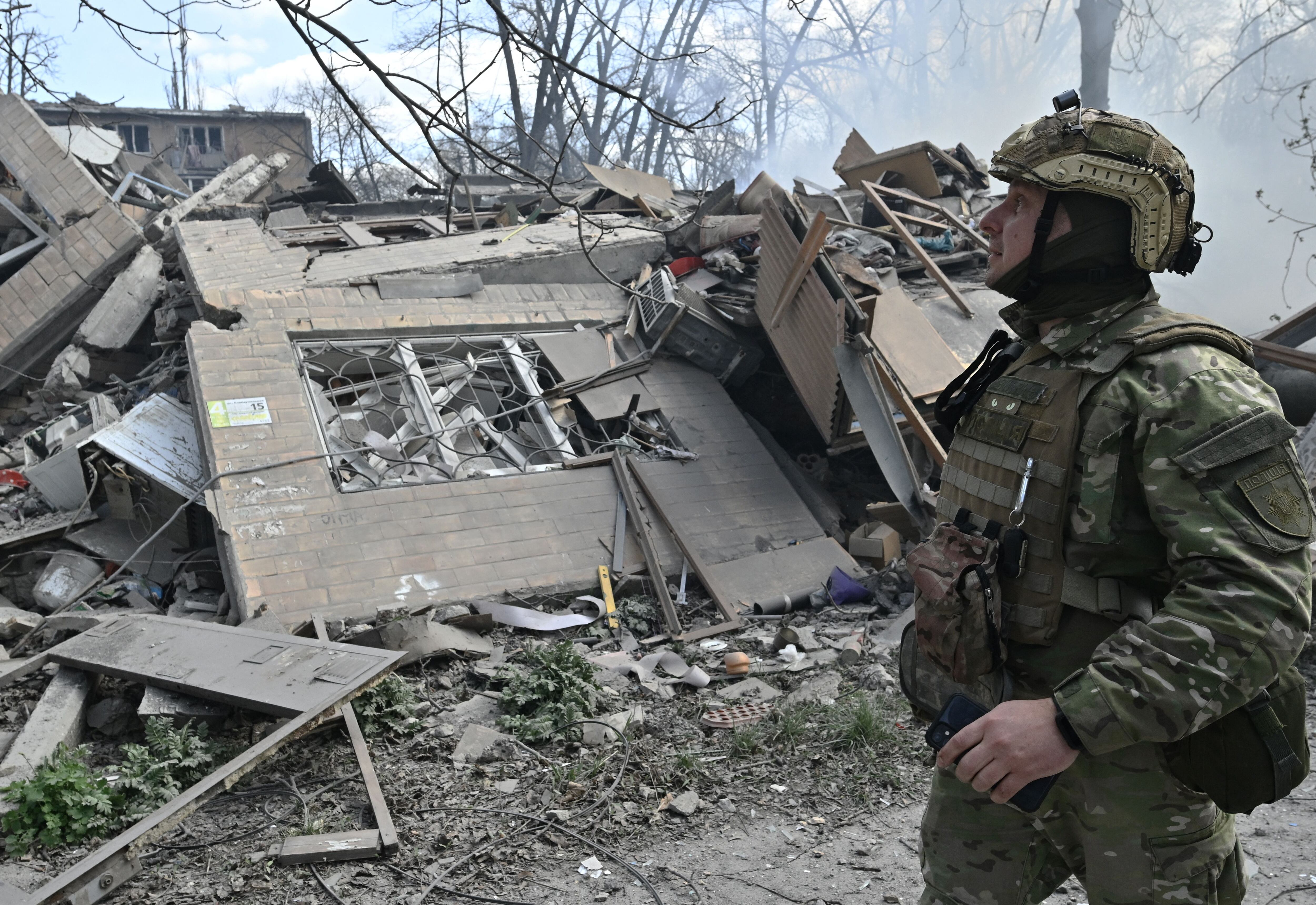 Un miembro del equipo especial de policía de los Ángeles Blancos de Ucrania camina mirando los escombros de un edificio residencial, destruido tras un ataque aéreo en la ciudad fronteriza de Avdiivka, región de Donetsk, el 10 de abril de 2023, en medio de la invasión rusa de Ucrania. (Foto de Genya SAVILOV / AFP / ARCHIVO)