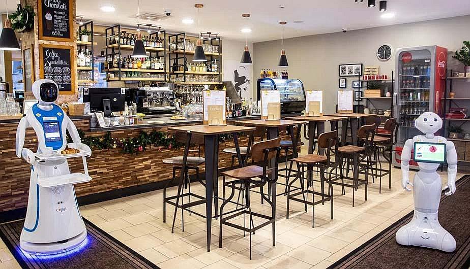 ​Androides sirven comidas y bebidas en un bar que muestra el futuro