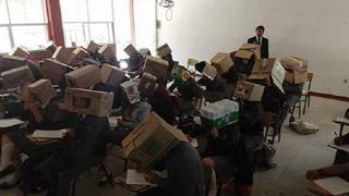 Alumnos toman examen con cajas de cartón en la cabeza para no copiar | FOTOS
