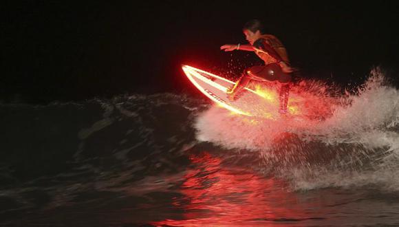 Vistoso surf nocturno de la mano de campeones es una sensación