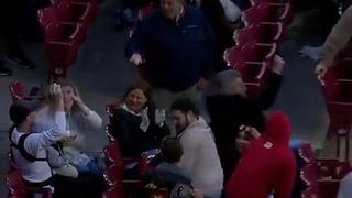 Espectador de un partido de béisbol hace increíble jugada mientras le da el biberón a su bebé [VIDEO]