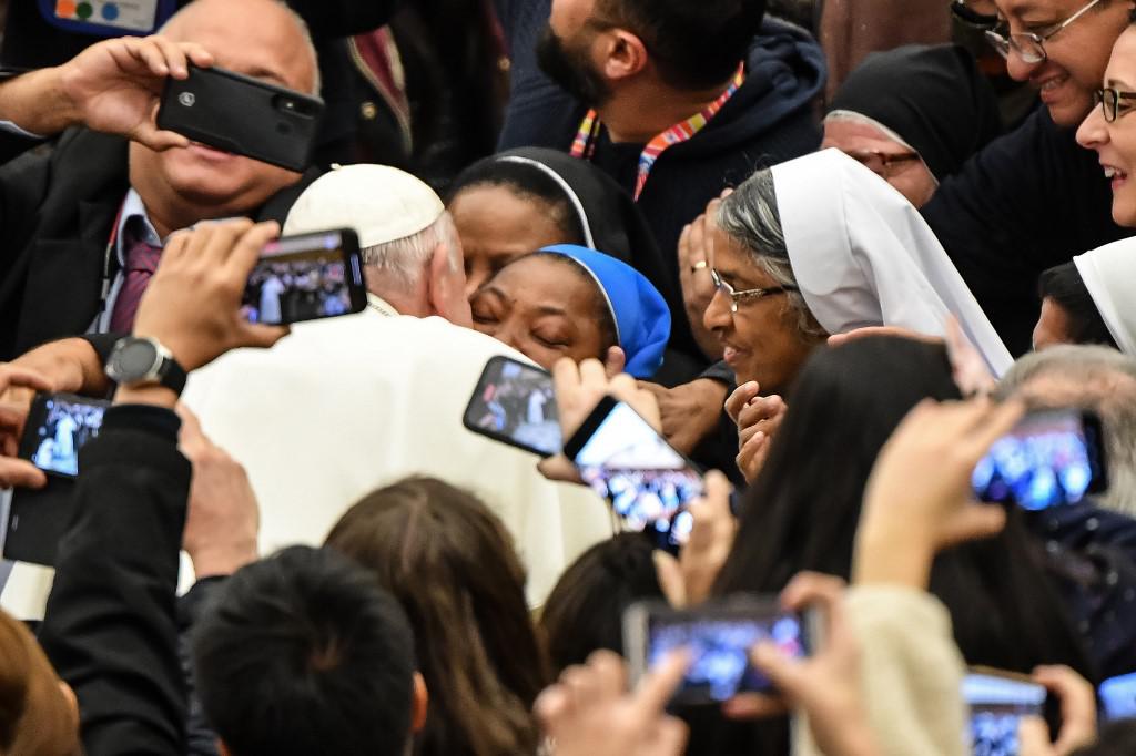 Pope Francis kisses a nun who had been shouting "Long live the pope!" as he arrives for the weekly general audience on January 8, 2020 at Paul-VI hall in the Vatican. - Pope Francis warned a nun not to bite him Wednesday in a joking reference to his run-in with an overly zealous pilgrim last week which saw him slap the woman's hand. "I'll give you a kiss, but you must stay calm. Don't bite!" he told the enthusiastic nun, who had been shouting "Long live the pope!" as Francis greeted pilgrims before his weekly general audience. (Photo by Andreas SOLARO / AFP)