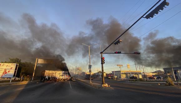 Se ven vehículos en llamas cruzados en la calle durante una operación para arrestar al hijo de Joaquín "El Chapo" Guzmán, Ovidio Guzmán, en Culiacán, estado de Sinaloa, México, el 5 de enero de 2023. (Foto por Marcos Vizcarra / AFP)