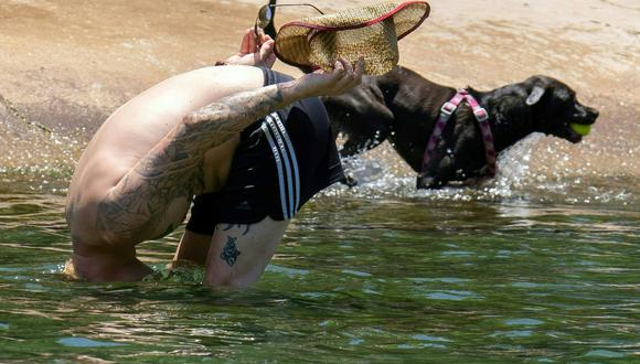 Un hombre sumerge la cabeza para refrescarse en Barton Creek Pool el 27 de junio de 2023 en Austin, Texas. (Foto por SUZANNE CORDEIRO / AFP)