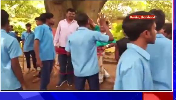 el profesor Suman Singh y dos funcionarios educativos son atados a un árbol. (Foto: Captura de video)