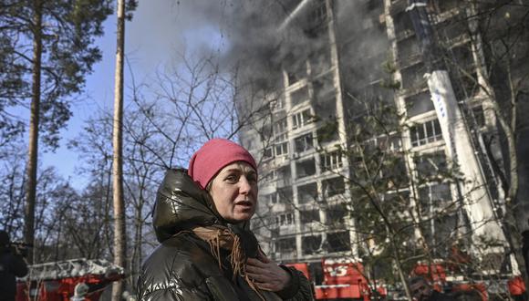 Una mujer reacciona frente a un edificio de apartamentos en llamas en Kiev. (Foto de Aris Messinis / AFP)