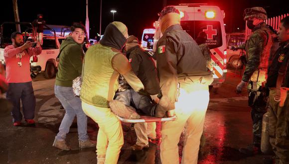 Oficiales de policía cargan a un migrante herido luego de un incendio que mató a decenas de migrantes, en la estación migratoria en Ciudad Juárez, estado de Chihuahua el 28 de marzo de 2023, donde al menos 39 personas murieron y decenas resultaron heridas luego de un incendio en la estación migratoria. (Foto por HERIKA MARTÍNEZ / AFP)