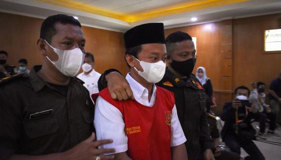 El maestro indonesio Herry Wirawan (C) es escoltado antes de su juicio en un tribunal en Bandung, Java Occidental, el 15 de febrero de 2022, donde luego fue sentenciado a cadena perpetua por la violación de 13 estudiantes, todos menores de edad. (Foto de TIMUR MATAHARI / AFP)