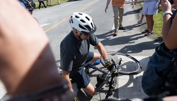 El presidente de EE.UU., Joe Biden, se cae de su bicicleta cuando se acerca a los simpatizantes después de un paseo en bicicleta en el Parque Estatal Gordon's Pond en Rehoboth Beach, Delaware, el 18 de junio de 2022. (Foto: SAUL LOEB / AFP)