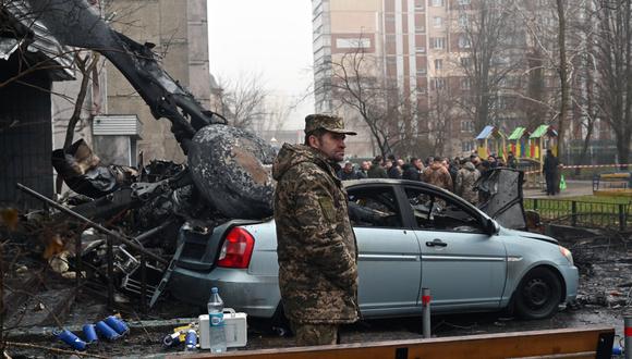 Un militar se encuentra en el lugar donde un helicóptero se estrelló cerca de un jardín de infantes en Brovary, en las afueras de la capital, Kyiv, y mató a 14 personas, incluidos dos niños y el ministro del Interior de Ucrania, el 18 de enero de 2023, en medio de la invasión rusa de Ucrania. (Foto de Serguéi SUPINSKY / AFP)