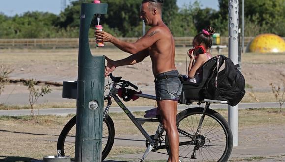Un hombre se sirve un poco de agua en un caluroso día de verano en Vicente López, cerca de Buenos Aires, el 13 de enero de 2022. (Foto de Alejandro PAGNI / AFP)