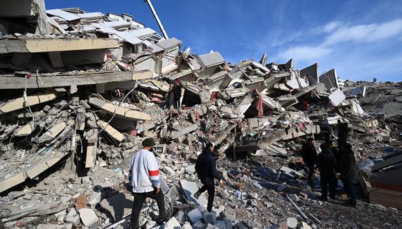 Los familiares de las víctimas se paran junto a los escombros de un edificio derrumbado en la ciudad de Kahramanmaras, en el sureste de Turquía, el 8 de febrero de 2023, dos días después de que un fuerte terremoto azotara la región. (Foto de OZAN KOSE / AFP)