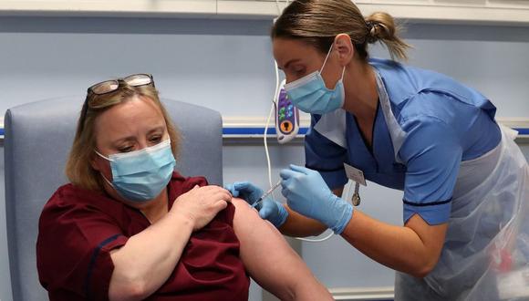La enfermera a cargo adjunta Katie McIntosh administra la primera de dos inyecciones de vacuna Pfizer / BioNTech Covid-19 a Vivien McKay Clinical Nurse Manager en el Western General Hospital en Edimburgo, Escocia. (Foto de Andrew Milligan/AFP).