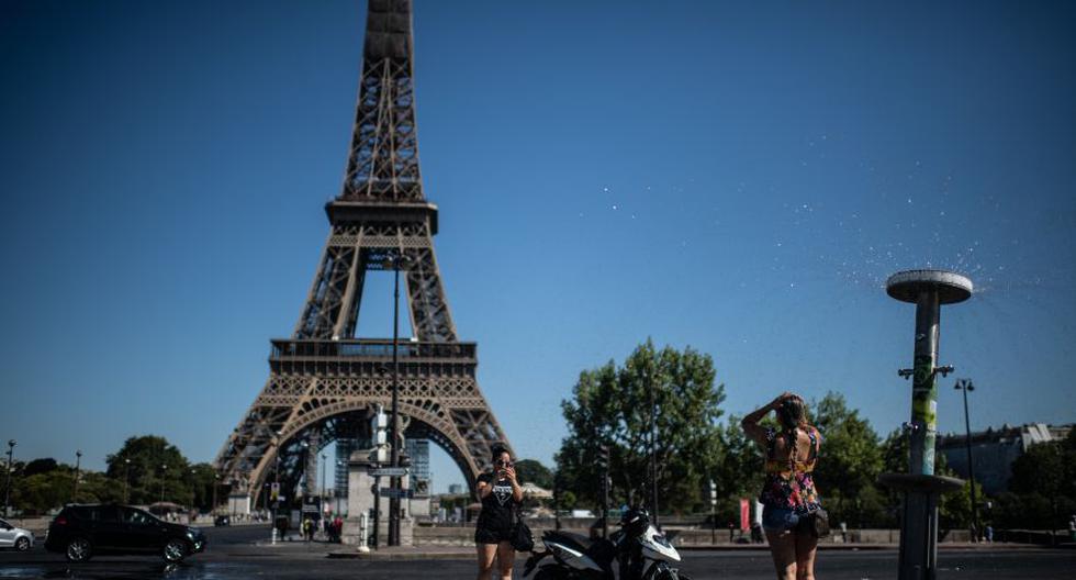 Los turistas se toman fotos ante la torre Eiffel Tower en Paris el 7 de agosto del 2020. (Foto: Martin BUREAU / AFP).