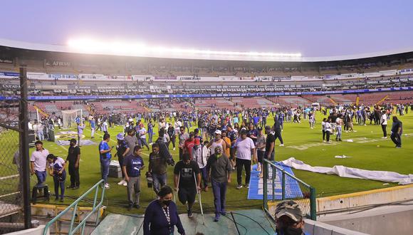 Aficionados del Querétaro y del Atlas se retiran tras un conato de pelea que terminó invadiendo la cancha, durante un juego correspondiente a la jornada 9 del Torneo Clausura 2022 de la Liga MX del fútbol mexicano. (Foto:  EFE/Sebastián Laureano Miranda)