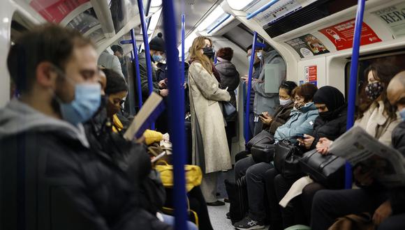 Los viajeros, la mayoría con cubiertas faciales para mitigar la propagación de Covid-19, viajan en un vagón de tren subterráneo de Transport for London (TfL) Victoria Line hacia el centro de Londres. (Foto: Tolga Akmen / AFP)