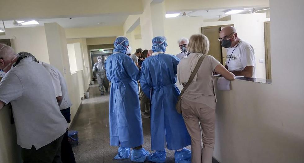 En esta foto del 3 de marzo de 2020 muestra a un grupo de turistas italianos hablando con el personal médico y llenan formularios después de ser puestos en aislamiento preventivo. (AFP)