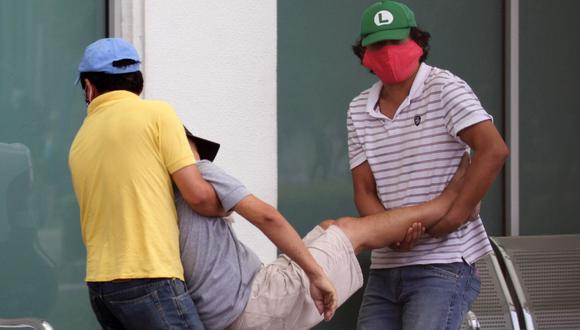 Men carry a sick man into a hospital in Guayaquil, Ecuador on April 1, 2020. - Residents of Guayaquil, in Ecuador's southwest, express outrage over the way the government has responded to the numerous deaths related to the novel coronavirus, COVID-19, saying there are many more deaths than are being reported and that bodies are being left in homes for days without being picked up. Ecuador marked its highest daily increase in deaths and new cases of coronavirus on Sunday, with the total reaching 14 dead and 789 infected, authorities had said. (Photo by Enrique Ortiz / AFP)