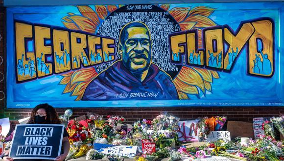 Las personas dejan flores, mensajes y globos cerca de un monumento improvisado a George Floyd en Minneapolis. El lunes inició el juicio a Derek Chauvin, el policía que lo mató. (Foto: AFP)