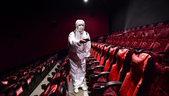 This photo taken on March 25, 2020 shows a staff member spraying disinfectant at a cinema as it prepares to reopen to the public after closing due to the COVID-19 coronavirus, in Shenyang in China's northeastern Liaoning province. - China lifted tough restrictions on the province at the epicentre of the coronavirus outbreak on March 25 after a months-long lockdown as the country reported no new domestic cases. (Photo by STR / AFP) / China OUT