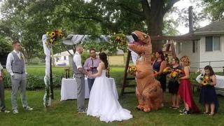 Dama de honor causa furor al ‘vestirse’ de Tiranosaurio Rex en boda de su hermana | VIDEO