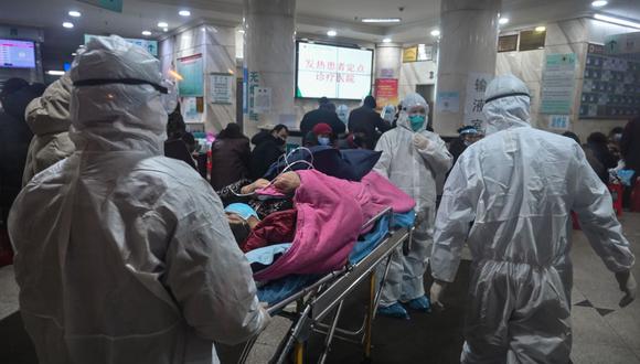 Personal médico, que usa ropa protectora para protegerse contra un coronavirus, atiende a un paciente en el Hospital de la Cruz Roja de Wuhan (Foto: AFP)