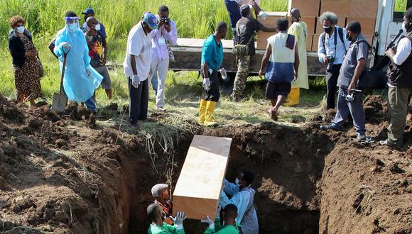 Se coloca un ataúd en una tumba durante un entierro masivo de al menos 54 personas que murieron por problemas no relacionados con Covid-19 en Port Moresby el 8 de diciembre de 2021. (Foto: Andrew KUTAN / AFP)