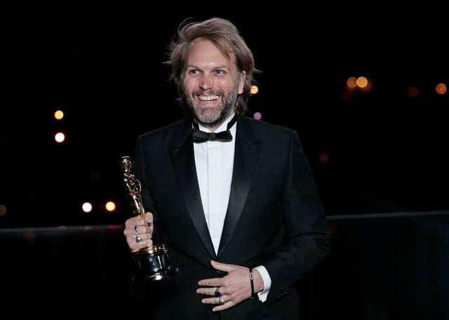 El novelista francés Florian Zeller sonríe mientras sostiene su estatuilla de los Oscar después de ganar el Mejor Guión Adaptado por "El Padre" en una proyección de los Oscar en las primeras horas del 26 de abril de 2021 en París, Francia. (Foto: Lewis Joly / POOL / AFP)