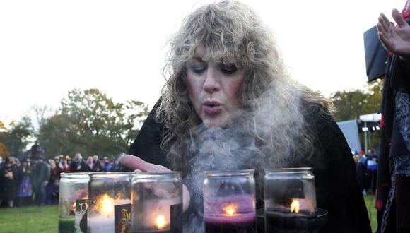 La bruja de Salem, Sandra Wright, sopla los vapores del incienso durante el Círculo Mágico de las Brujas de Salem en Salem Common en Halloween en Salem, MA, el 31 de octubre de 2018. (Foto de José PREZIOSO / AFP)