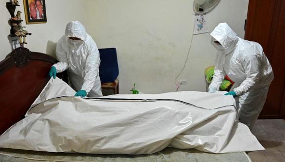 Trabajadores de una funeraria se preparan para llevar el cadáver de un hombre que murió de coronavirus en Cali, Colombia, el 26 de julio de 2020. (Foto de Luis ROBAYO / AFP).