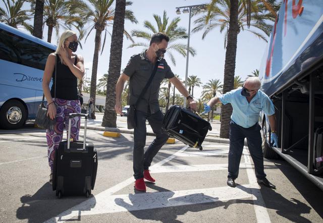 Los turistas alemanes se preparan para abordar un autobús a su llegada al aeropuerto de Son San Joan, en Palma de Mallorca, como parte de un programa piloto para reactivar el turismo en España. (JAIME REINA / AFP)